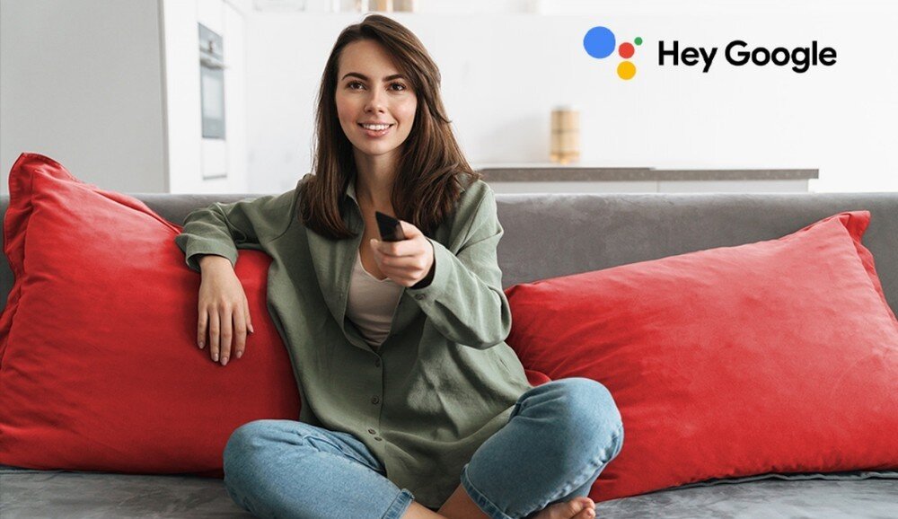 Telewizor SHARP 43HL4765E, wbudowany Asystent Google, sterowanie głosowe, wyszukiwanie filmów, seriali i kanałów, osoba siedzaca na kanapie z pilotem w ręku