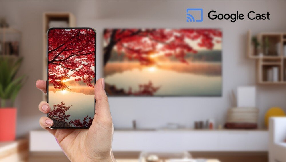 Telewizor SHARP 43HL4765E, Google Cast, Wi-Fi, bezprzewodowe przesyłanie obrazu z telefonu i komputera na ekran, telefon trzymany w ręku, telewizor zawieszony na scianie w pomieszczeniu