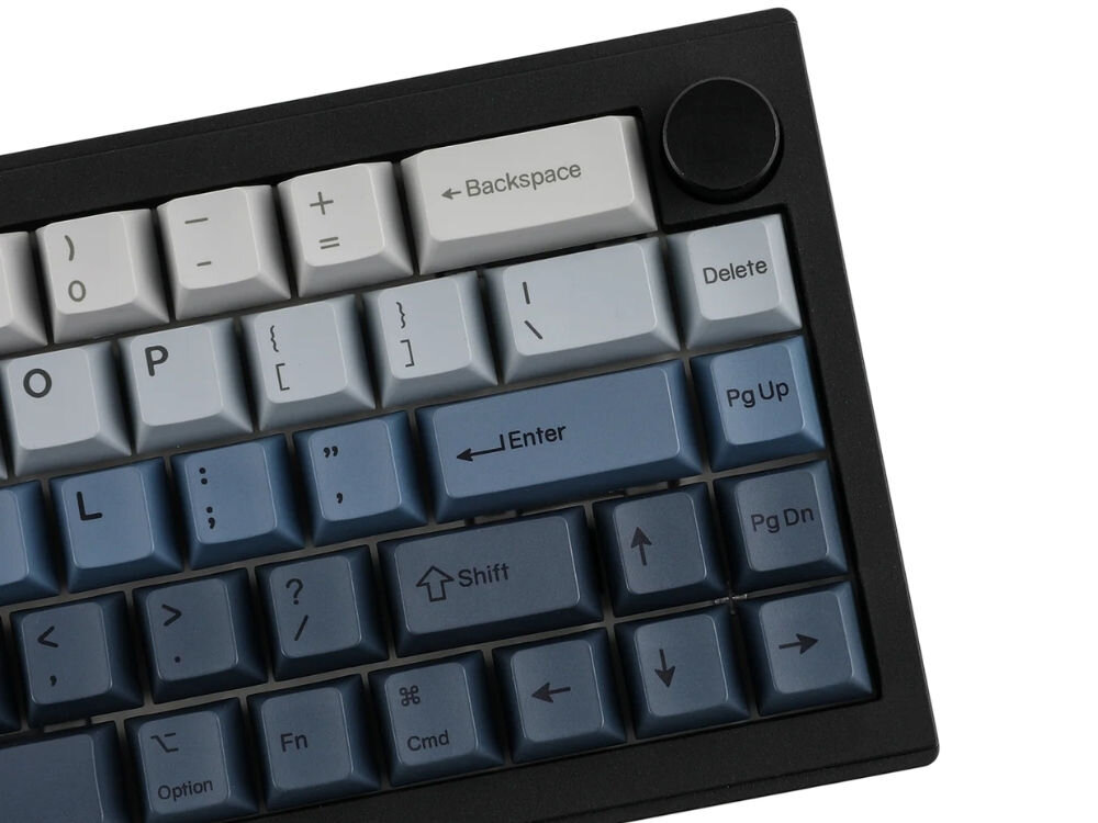 Na obrazie widoczna jest klawiatura z klawiszami w odcieniach szarości i niebieskiego. Klawisze mają oznaczenia takie jak \'Backspace\', \'Delete\', \'Enter\', \'Shift\', \'Pg Up\', \'Pg Dn\', a w rogu znajduje się czarny pokrętło.