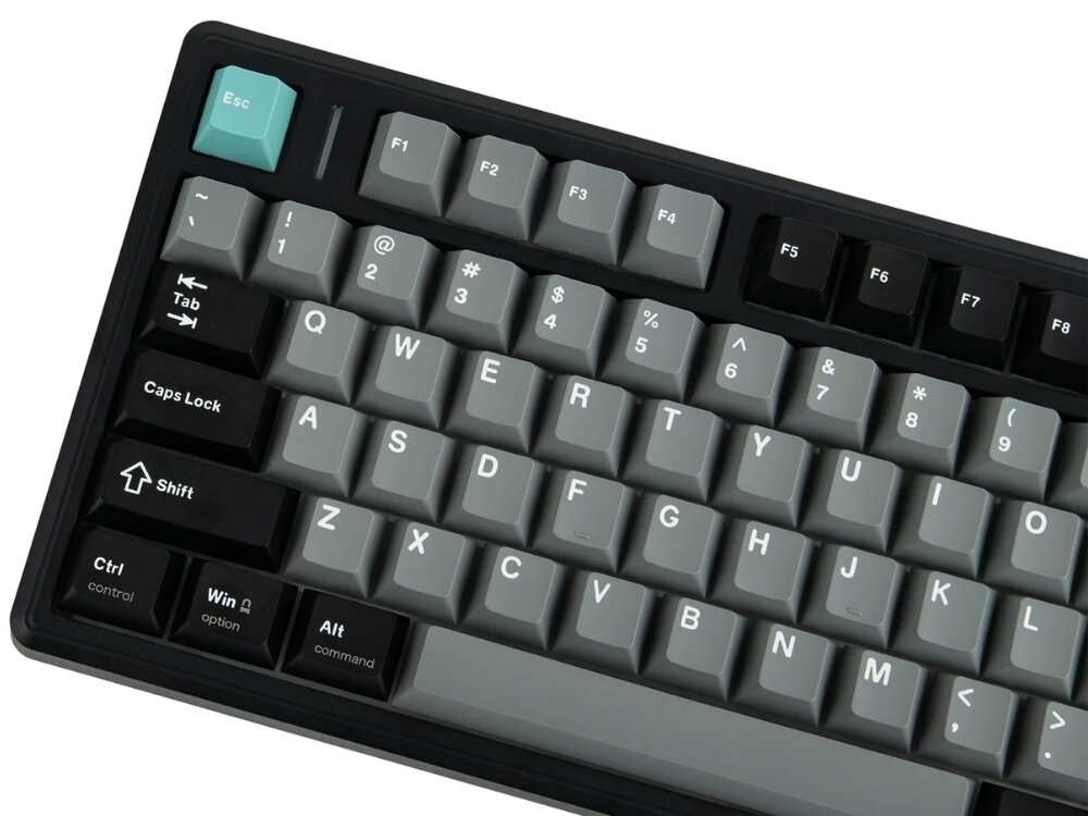 Klawiatura mechaniczna z klawiszami w kolorach czarnym, szarym i jednym turkusowym klawiszem \'Esc\'. Widoczne są klawisze funkcyjne F1-F8 oraz standardowy układ QWERTY.