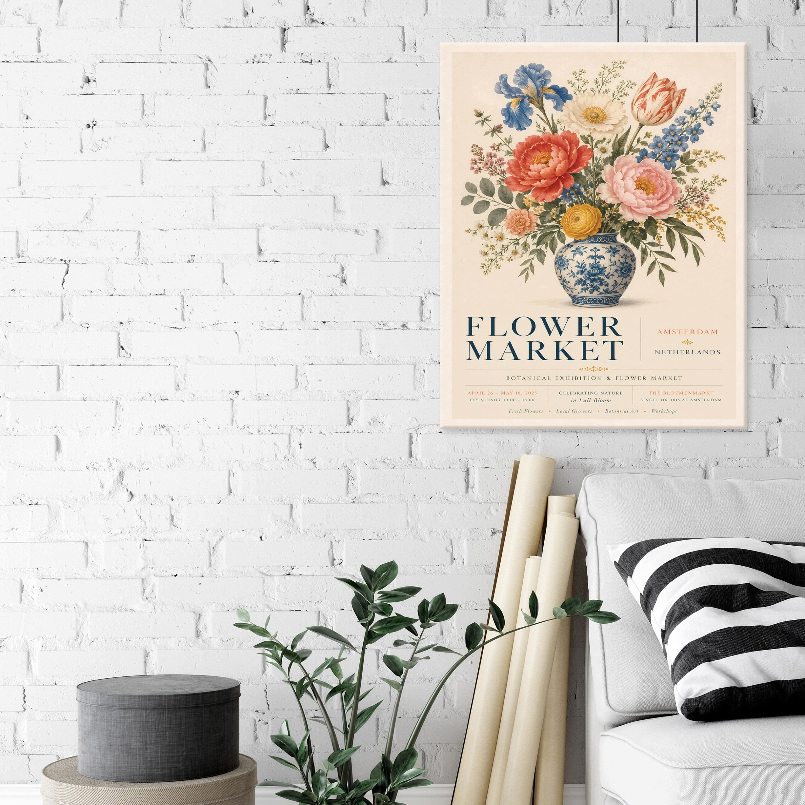 Na białej ceglanej ścianie wisi obraz przedstawiający bukiet kwiatów w niebiesko-białym wazonie z napisem \'FLOWER MARKET\'. Obok znajduje się szara sofa z poduszką w czarno-białe paski oraz zielona roślina w doniczce.