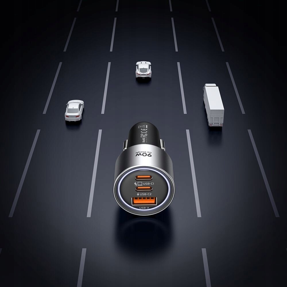 Na ciemnym tle przedstawiona jest szybka ładowarka samochodowa z trzema portami: dwoma USB-C i jednym USB-A. Na ładowarce widoczny jest napis \'90W\'.