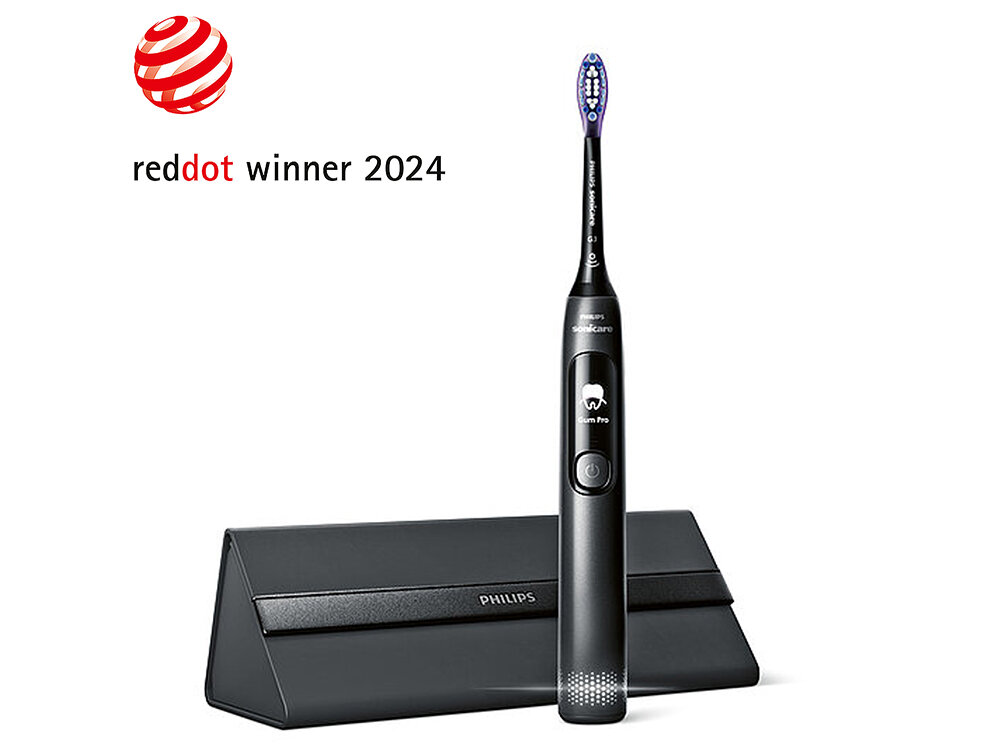 Czarna szczoteczka soniczna z napisem \'Sonicare\' i symbolem zęba na uchwycie, stojąca przed czarnym etui z napisem \'PHILIPS\'. Widoczny jest również napis \'reddot winner 2024\' z czerwonym logo w kształcie kuli.