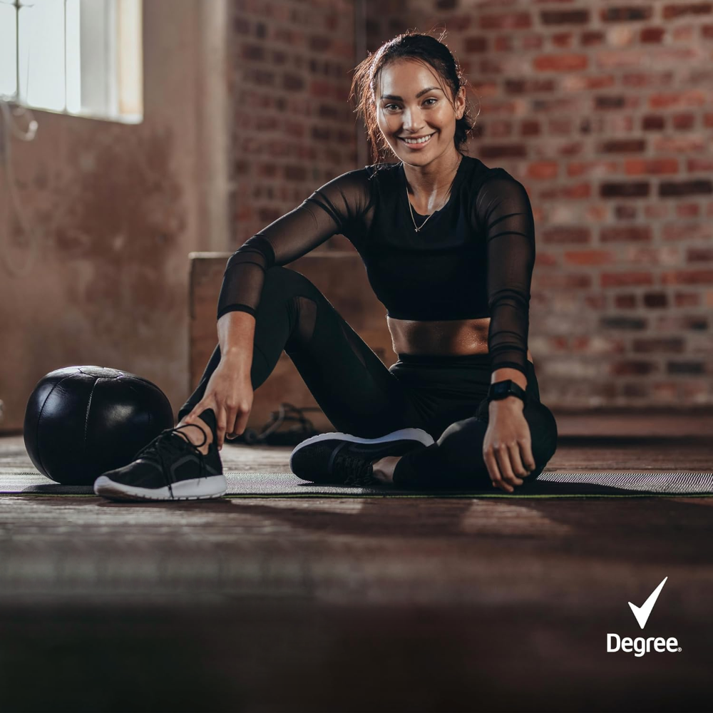 Osoba w sportowym stroju siedzi na macie w pomieszczeniu z ceglaną ścianą. W prawym dolnym rogu widoczne jest logo \'Degree\'.