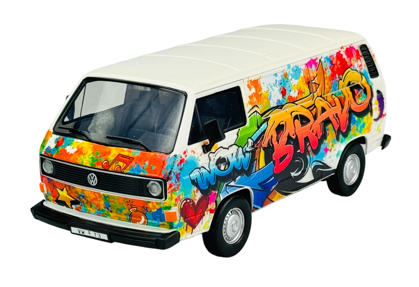 Model samochodu Volkswagen Transporter T3 z kolorowym graffiti na bokach, z napisem \'WOW BRAVO\'. Na przodzie widoczne jest logo VW oraz tablica rejestracyjna z napisem \'VW T3\'.