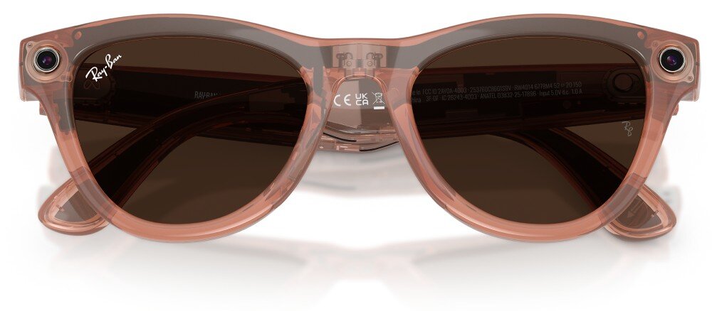 Okulary przeciwsłoneczne w kolorze brzoskwiniowym z ciemnymi soczewkami, posiadające logo \'Ray-Ban\' na zauszniku. Na oprawkach widoczne są małe kamery po obu stronach.