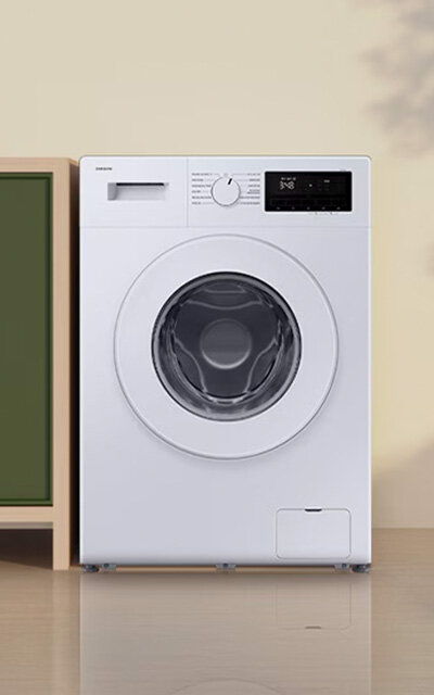 Pralka Slim 9kg WW90FG3M05TWEO Biała pralka z okrągłym oknem na drzwiach, panelem sterowania z pokrętłem i wyświetlaczem. Obok pralki znajduje się zielona szafka.