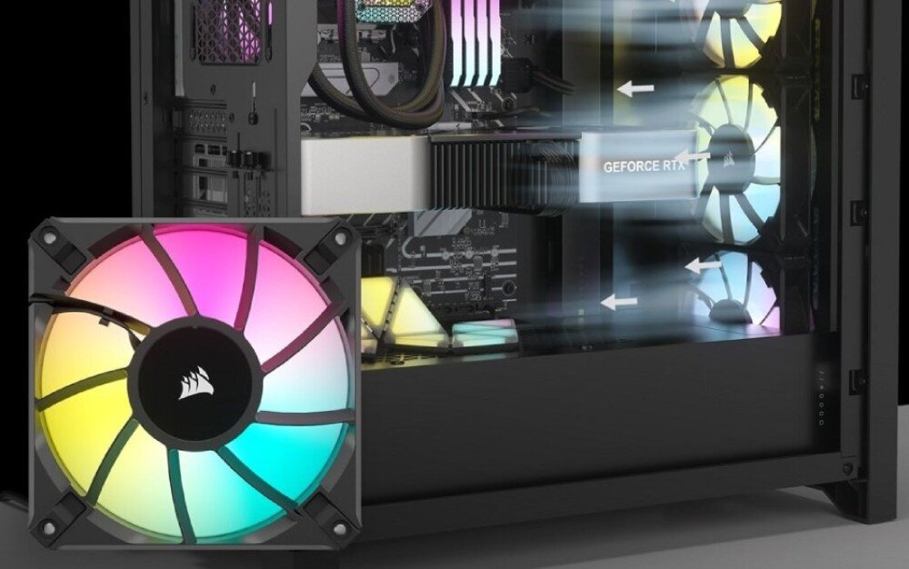Obraz przedstawia wnętrze obudowy komputera z widocznymi wentylatorami RGB emitującymi kolorowe światło. Na jednym z elementów widoczny jest napis \'GEFORCE RTX\'.