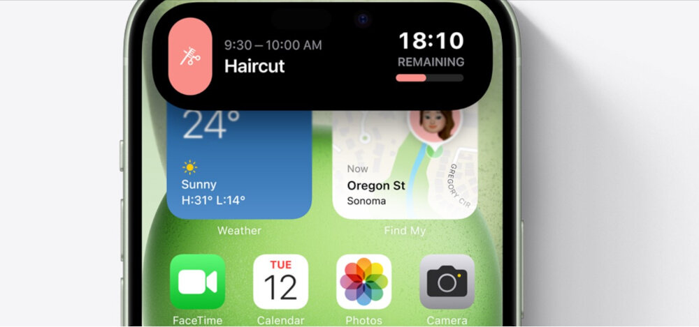 Ekran smartfona z widocznymi ikonami aplikacji i widgetami. Widoczny tekst: \'Haircut\', \'24°\', \'Sunny\', \'H:31° L:14°\', \'Oregon St\', \'Sonoma\', \'FaceTime\', \'Calendar\', \'Photos\', \'Camera\'.