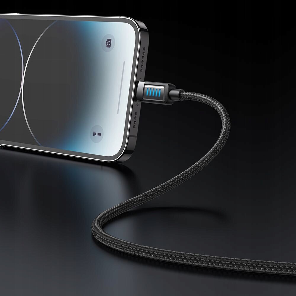Na obrazie widać smartfon z podłączonym kablem USB-A Lightning, który ma plecioną osłonę i świecący na niebiesko wskaźnik LED. Ekran telefonu jest włączony, ale nie wyświetla żadnych treści.