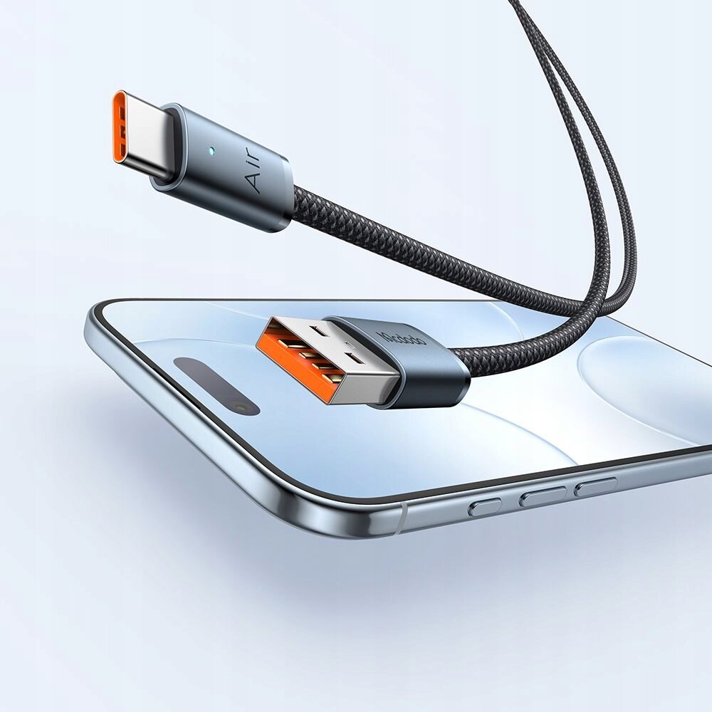 Na obrazie widoczny jest kabel USB z końcówkami USB-A i USB-C, podłączony do smartfona. Na końcówce USB-C znajduje się napis \'AIR\', a na końcówce USB-A widoczny jest napis \'Mcdodo\'.