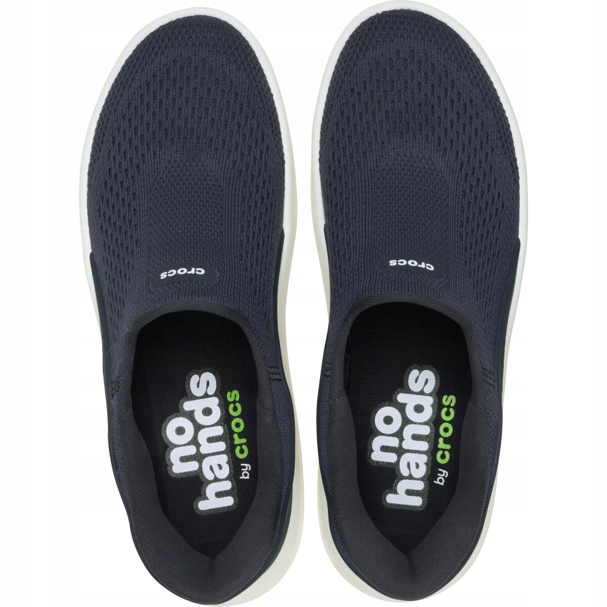 Para ciemnoniebieskich butów sportowych typu slip-on z białą podeszwą. Na wkładkach widoczny jest tekst: \'no hands by crocs\'.