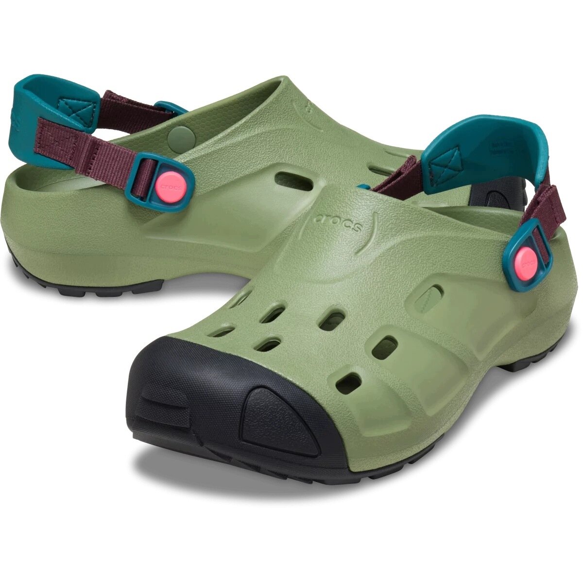 Zielone chodaki z czarnymi noskami i kolorowymi paskami z zapięciem. Na powierzchni widoczne są otwory wentylacyjne oraz logo \'crocs\'.