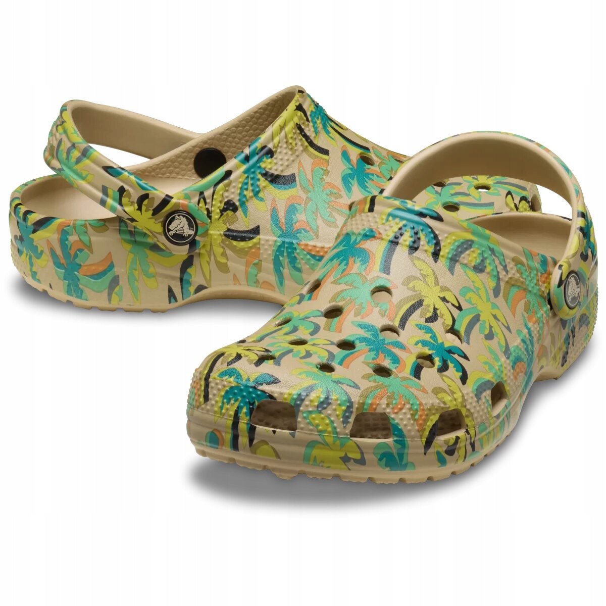 Damskie buty typu chodaki z kolorowym wzorem przedstawiającym palmy na beżowym tle. Buty mają otwory wentylacyjne i pasek na piętę z okrągłym logo producenta.