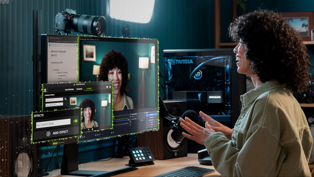 Na biurku znajduje się monitor z wyświetlonym oprogramowaniem do edycji wideo oraz komputer z widocznym logo NVIDIA. Obok monitora stoi aparat fotograficzny na statywie.