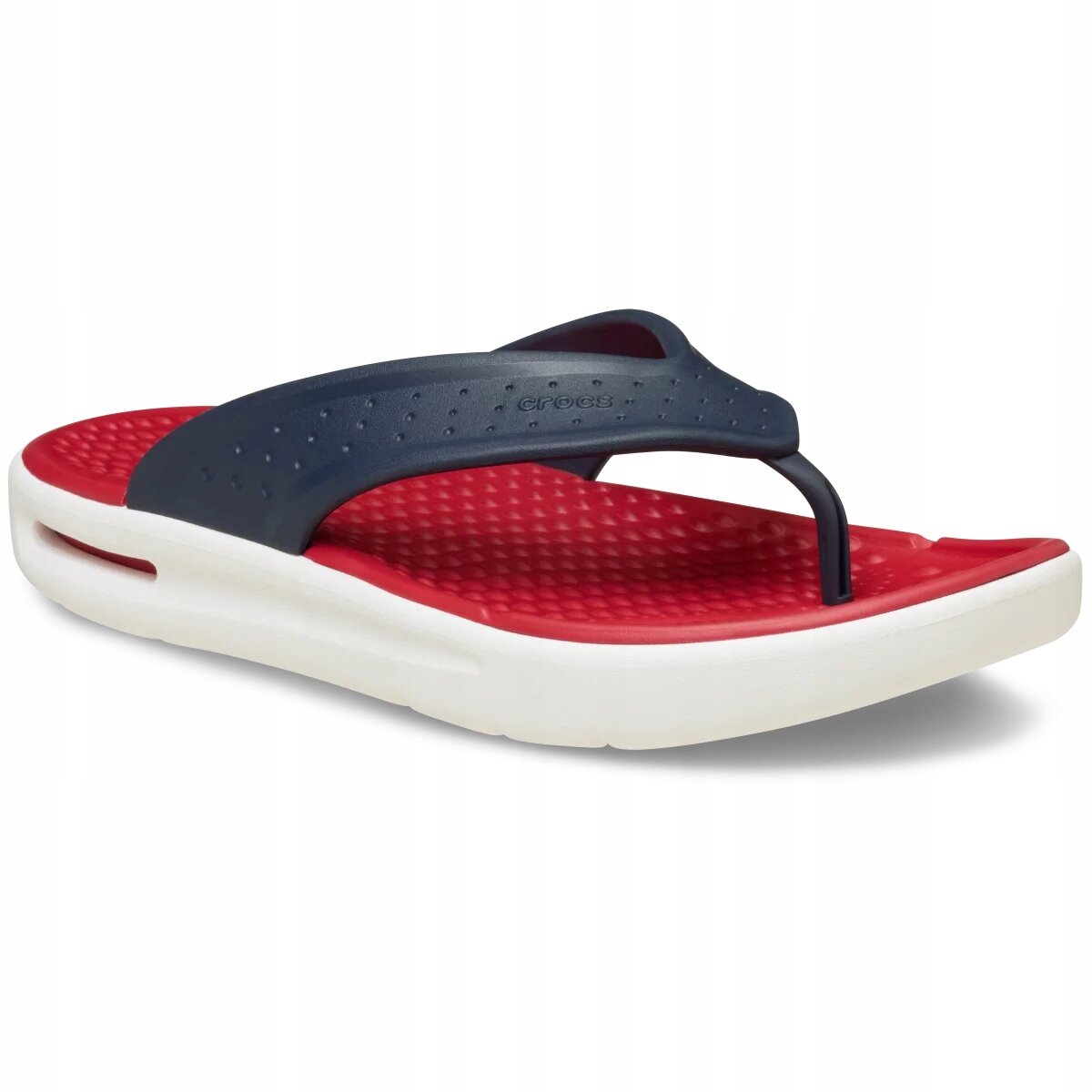 Na obrazie widoczne są japonki z czerwonym wnętrzem i białą podeszwą, z ciemnym paskiem na górze. Na pasku znajduje się logo \'crocs\'.
