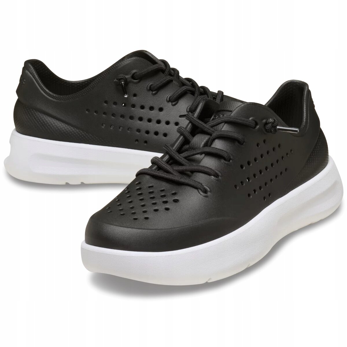 Czarne buty sportowe z białą podeszwą, posiadające perforacje na powierzchni i sznurowadła. Buty mają nowoczesny design i są przeznaczone do codziennego użytku.