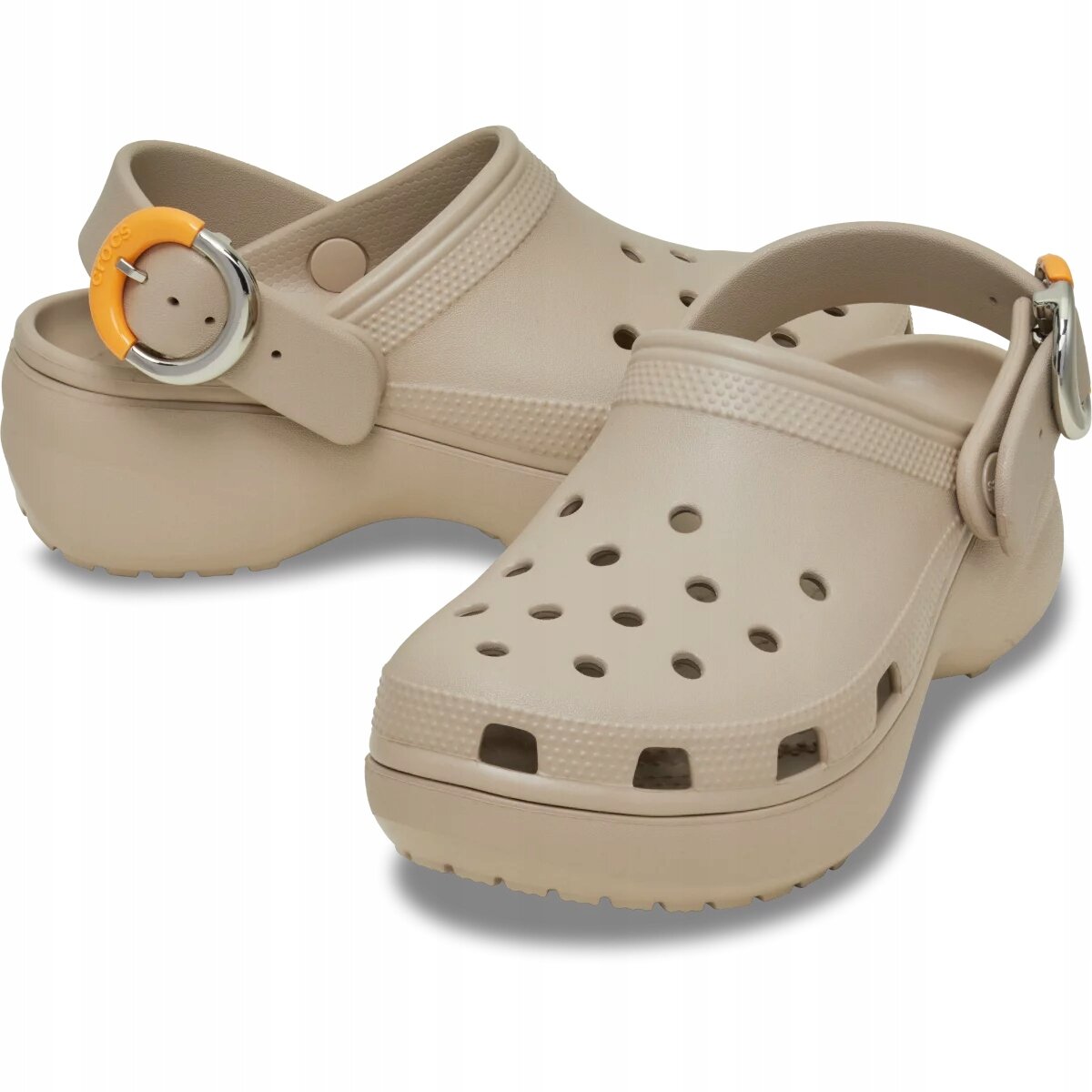 Beżowe buty typu clog z platformą, posiadające otwory wentylacyjne na górze i regulowany pasek z metalową klamrą oraz pomarańczowym elementem z napisem \'Crocs\'.