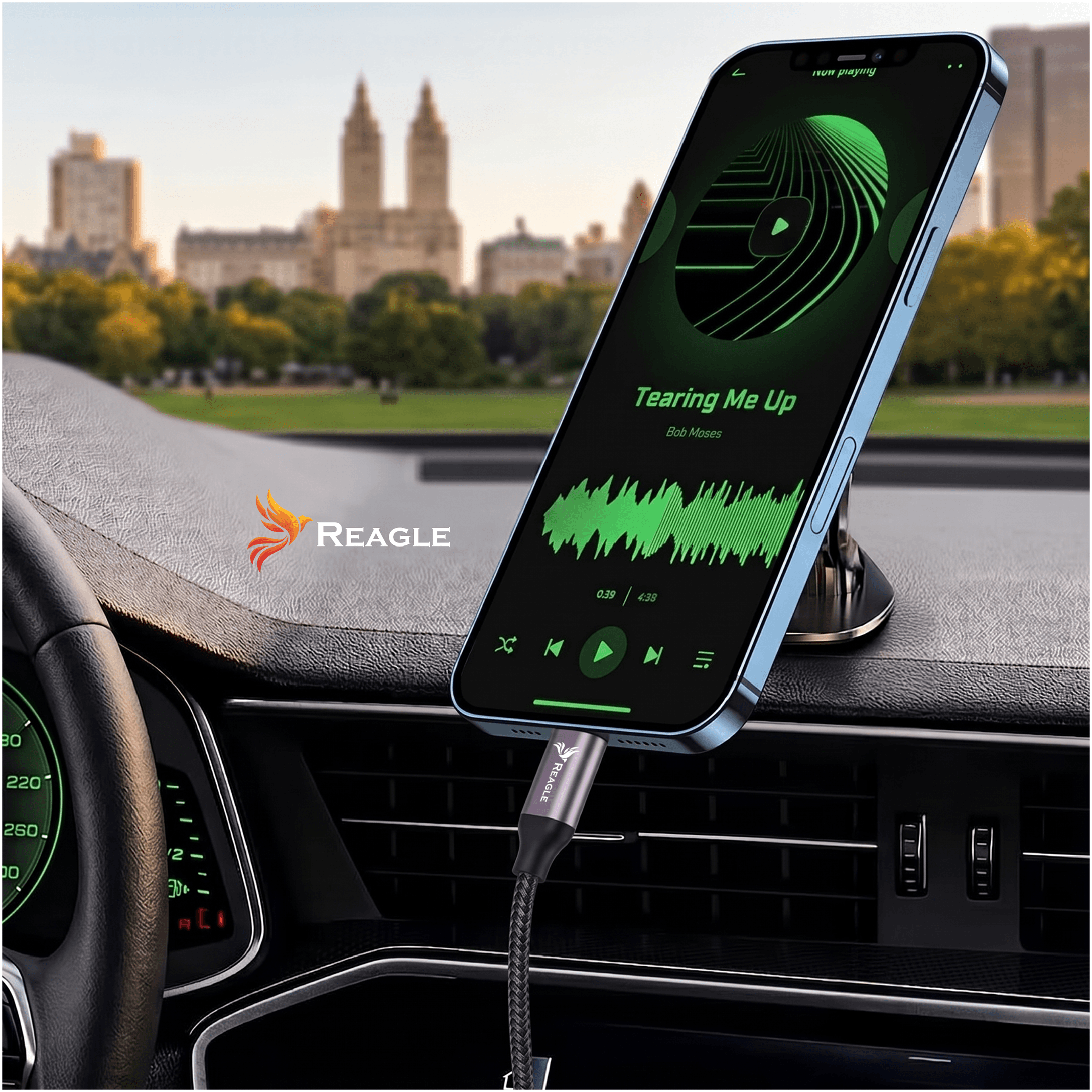 Smartfon zamocowany na desce rozdzielczej samochodu odtwarza utwór \'Tearing Me Up\' Bob Moses. Widoczny jest kabel z logo \'Reagle\' podłączony do telefonu.