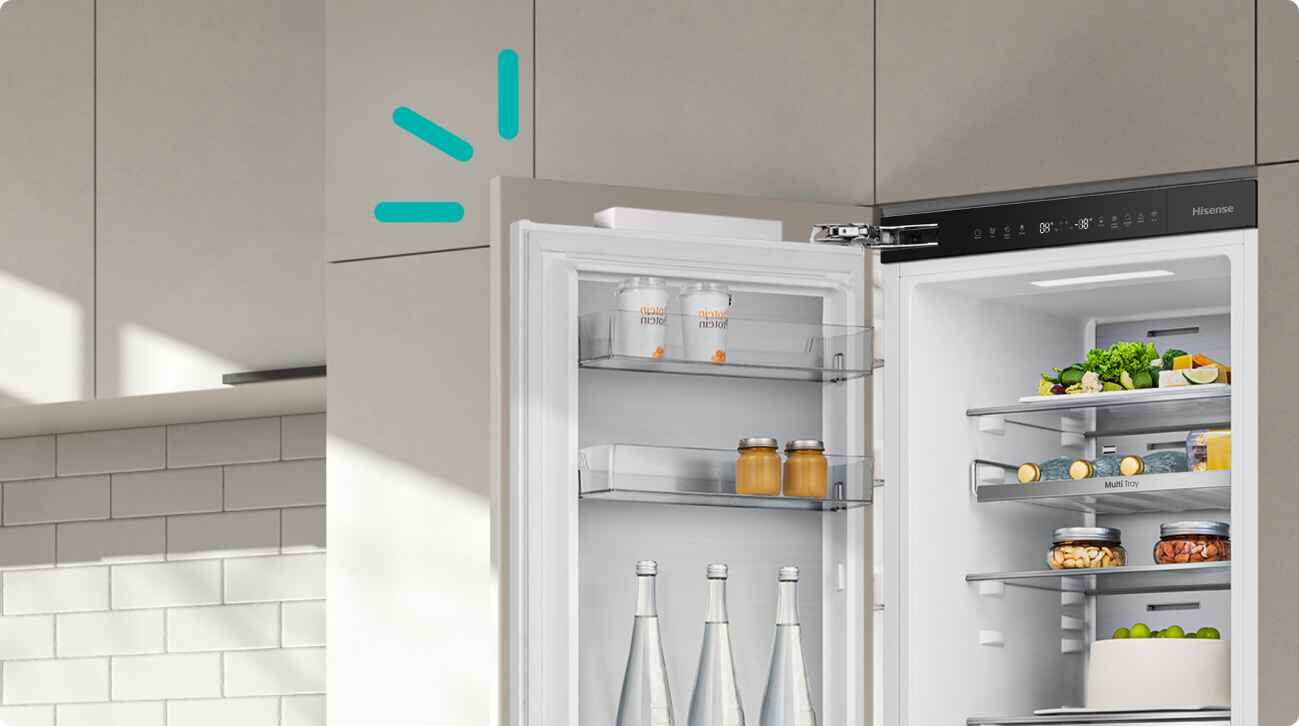 Otwarta lodówka z widocznymi półkami, na których znajdują się butelki, słoiki i pojemniki z jedzeniem. Na drzwiach lodówki widoczny jest panel sterowania z logo Hisense.