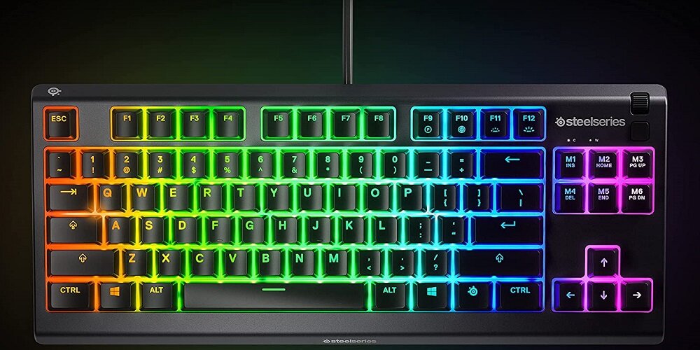Klawiatura z podświetleniem RGB, z widocznymi klawiszami funkcyjnymi i numerycznymi. Logo \'steelseries\' znajduje się w prawym górnym rogu.