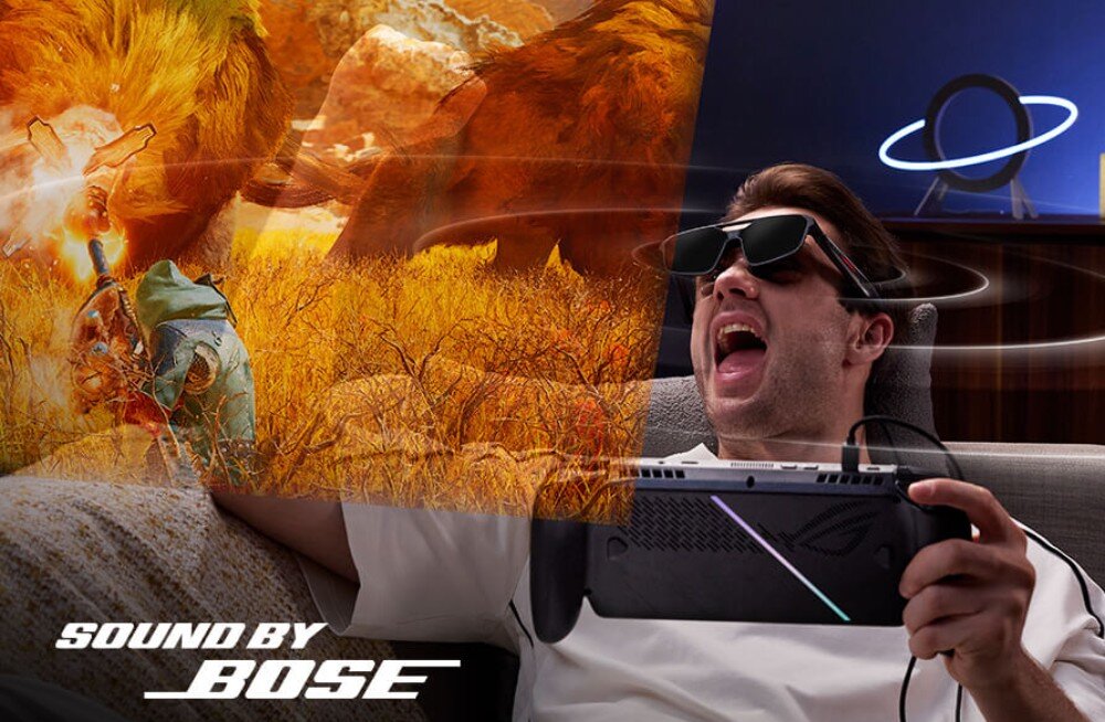 Osoba siedzi na kanapie, nosząc okulary do rzeczywistości rozszerzonej i trzymając urządzenie z logo ROG. Na obrazie widoczny jest napis \'SOUND BY BOSE\' oraz scena z gry przedstawiająca postać i lwa.