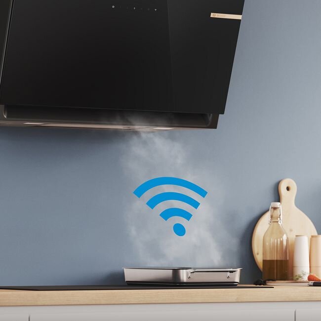 Na obrazie widoczny jest czarny okap kuchenny nad płytą grzewczą, z której unosi się para. Na ścianie znajduje się niebieski symbol Wi-Fi, a obok stoją butelki i deska do krojenia.