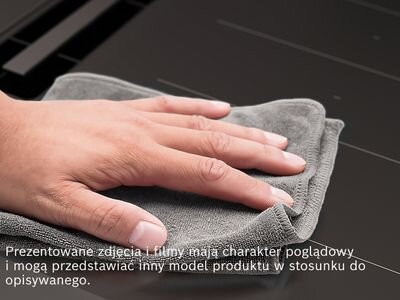 Osoba przeciera szmatką powierzchnię płyty indukcyjnej. Tekst na obrazie: \'Prezentowane zdjęcia i filmy mają charakter poglądowy i mogą przedstawiać inny model produktu w stosunku do opisywanego.\'