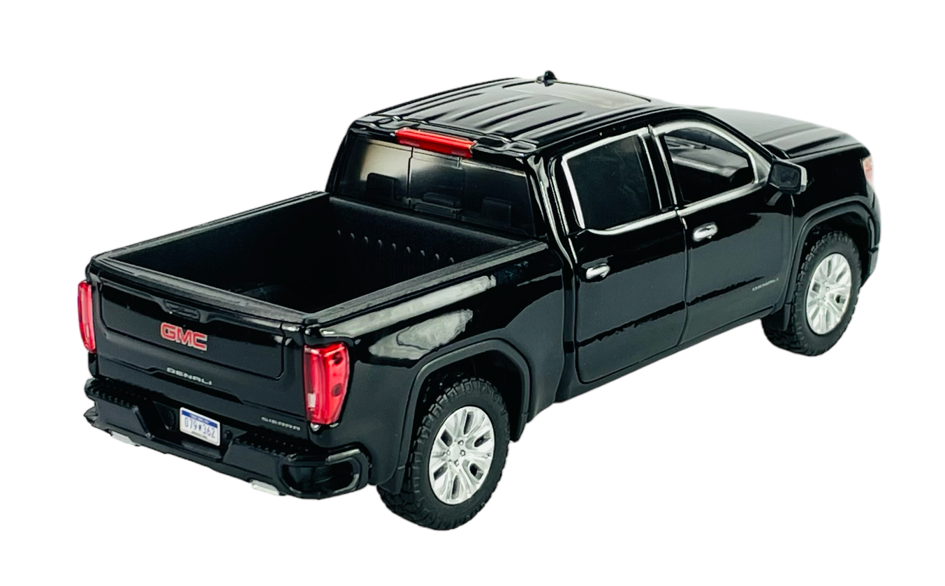 Czarny model samochodu typu pickup z widocznym logo GMC na tylnej klapie. Samochód ma cztery drzwi i srebrne felgi.