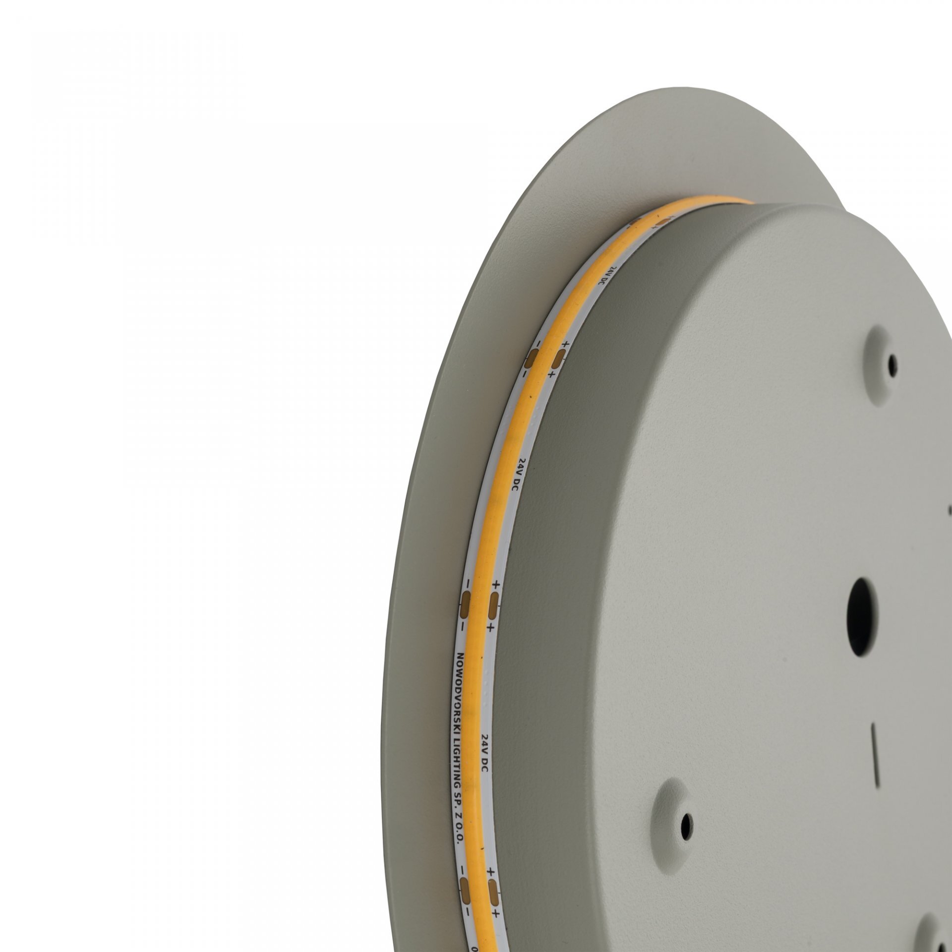 Obraz przedstawia okrągłą lampę ścienną z widocznym paskiem LED na krawędzi. Na pasku LED znajduje się tekst: \'24V DC, MONOPHONIC LIGHTING, 57.0 D.\'.