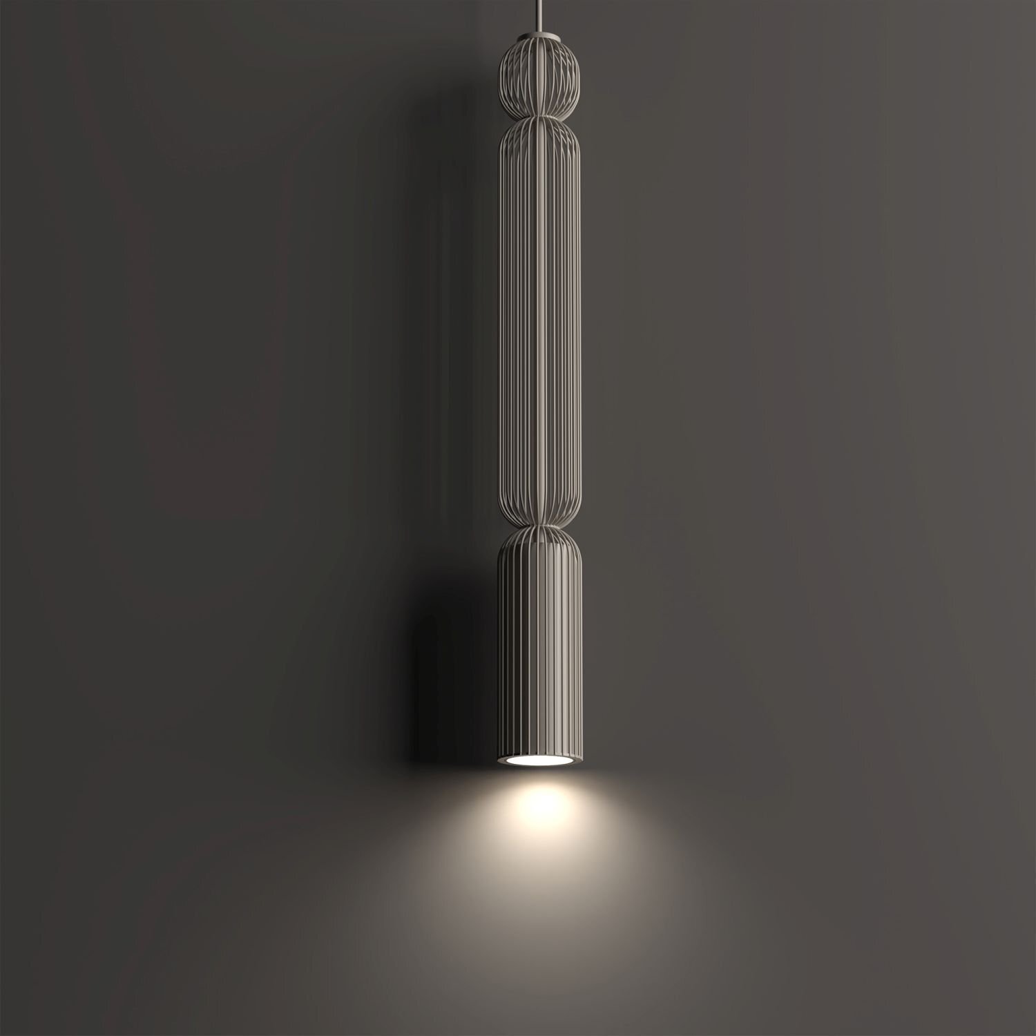 Na obrazie widoczna jest nowoczesna lampa wisząca o cylindrycznym kształcie z metalowymi prętami, emitująca światło skierowane w dół. Tło jest jednolite i ciemne, co podkreśla jasność światła.