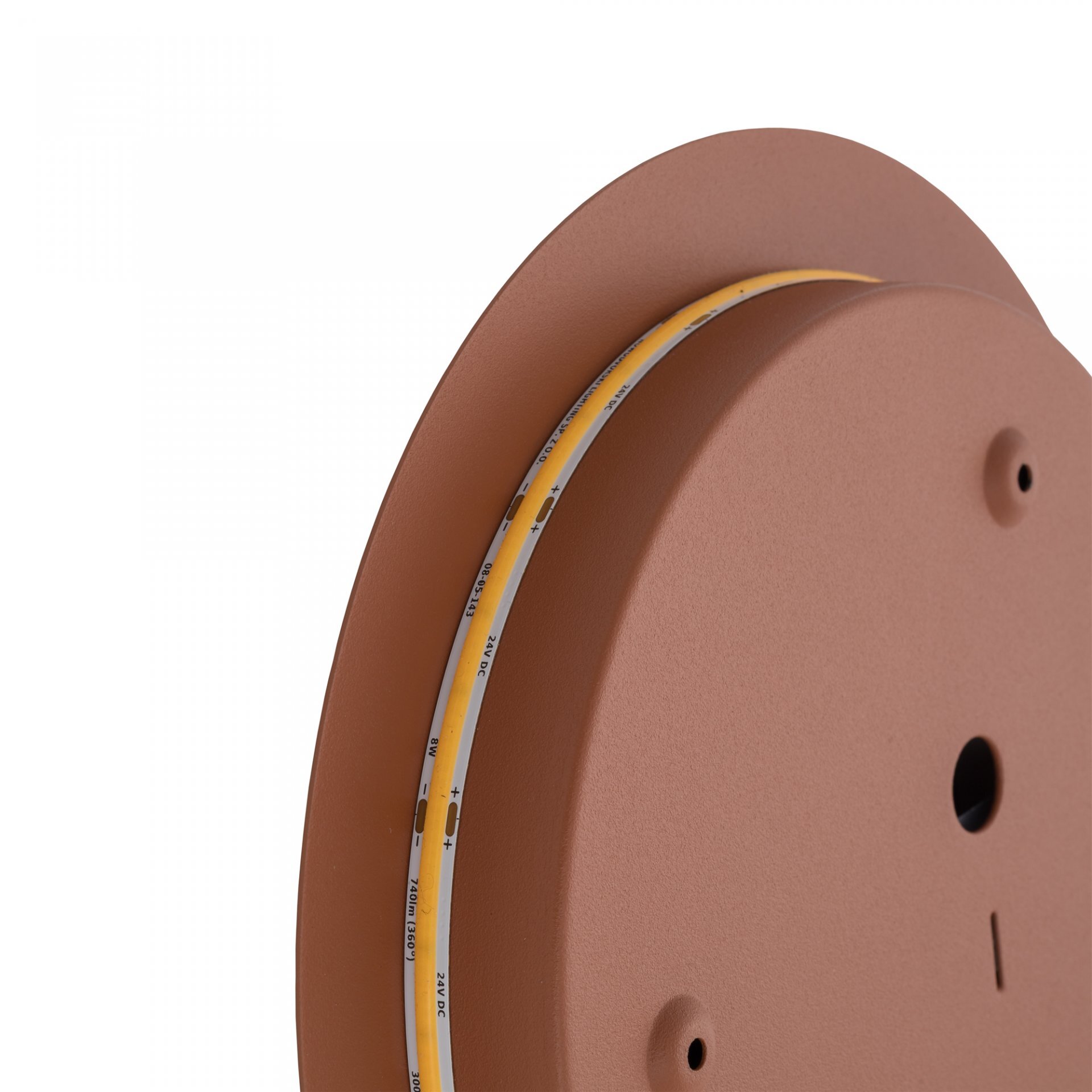 Brązowa lampa ścienna o okrągłym kształcie z widocznym paskiem LED na krawędzi. Na pasku LED znajdują się oznaczenia: \'24V DC\', \'+\', \'-\', \'12W\'.