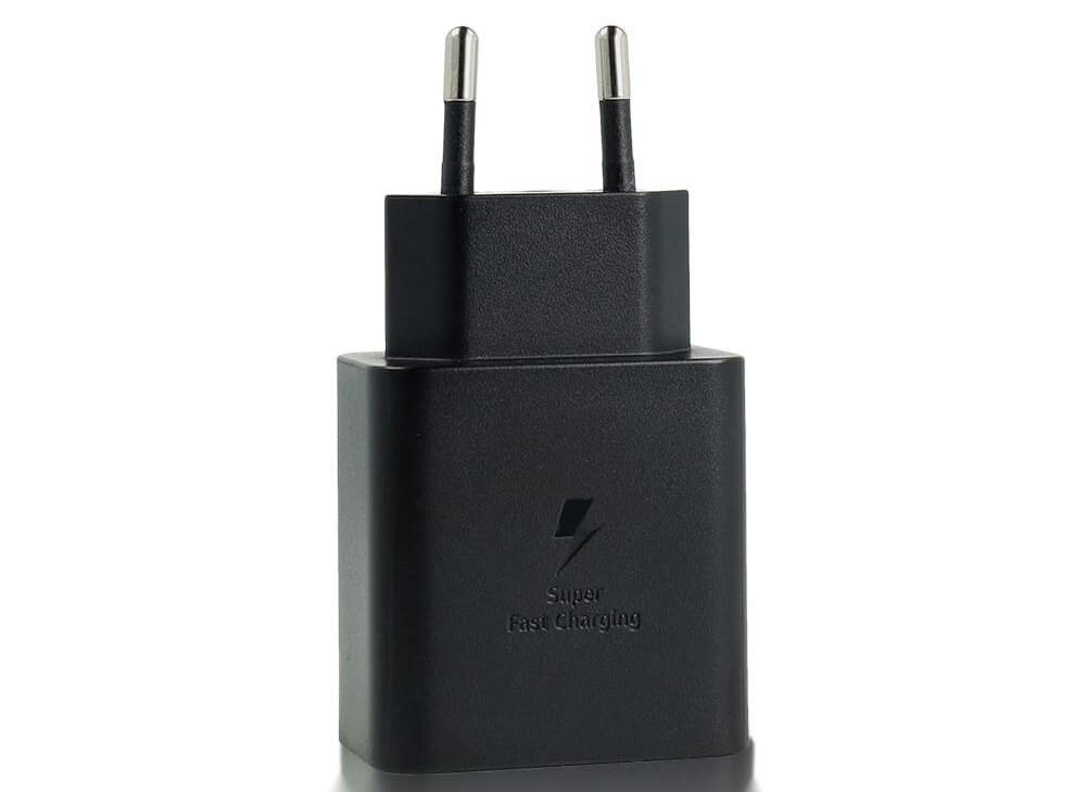Czarna ładowarka sieciowa z dwoma metalowymi bolcami i napisem \'Super Fast Charging\' na obudowie.