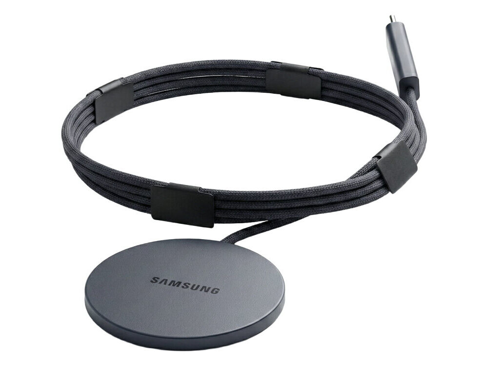 Na obrazie widoczna jest czarna ładowarka indukcyjna z okrągłą podstawą, na której znajduje się napis \'SAMSUNG\'. Kabel jest opleciony materiałem i zakończony wtyczką USB-C.