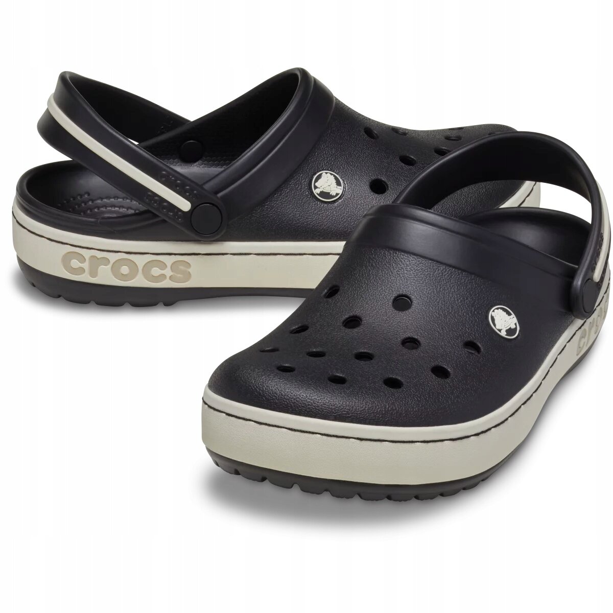 Czarne chodaki z otworami wentylacyjnymi i paskiem na piętę, z białą podeszwą z napisem \'crocs\'.