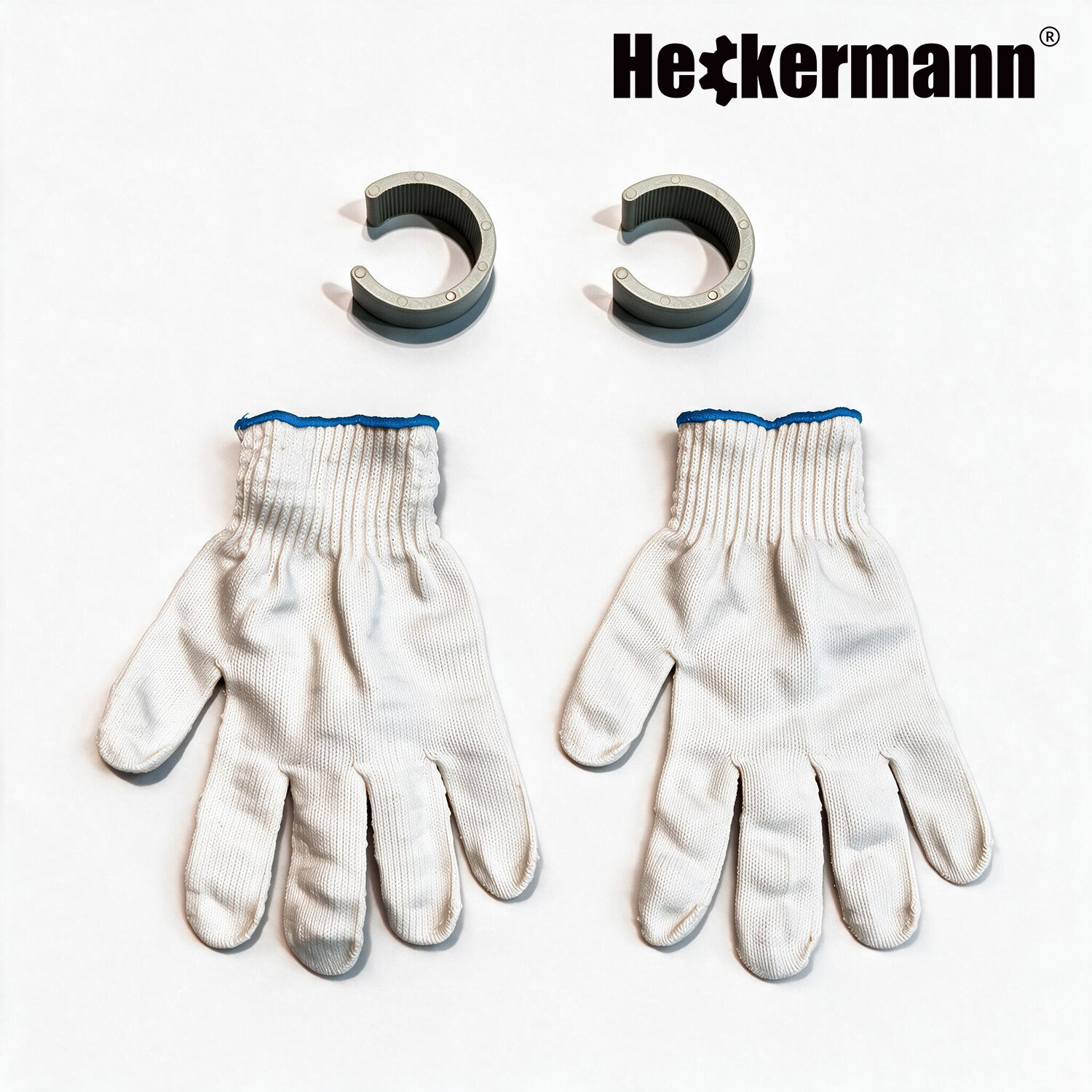 Na białym tle znajdują się dwie pary białych rękawic roboczych oraz dwa szare uchwyty w kształcie litery C. W prawym górnym rogu widoczne jest logo \'Heckermann\'.