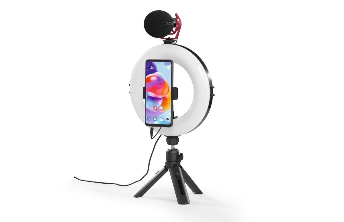 Lampa pierścieniowa LED z zamocowanym smartfonem i mikrofonem na statywie. Logo \'hama\' widoczne na mikrofonie.