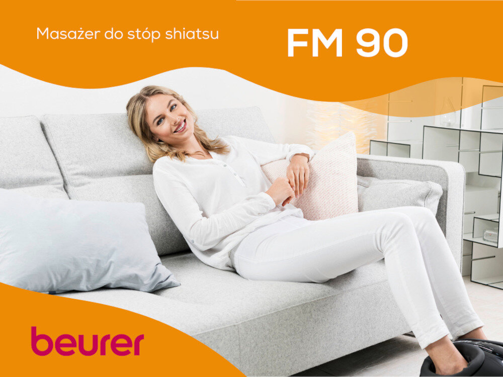 Osoba siedzi na jasnej kanapie, trzymając poduszkę. Na obrazie widoczny jest tekst: \'Masażer do stóp shiatsu FM 90\' oraz logo \'beurer\'.