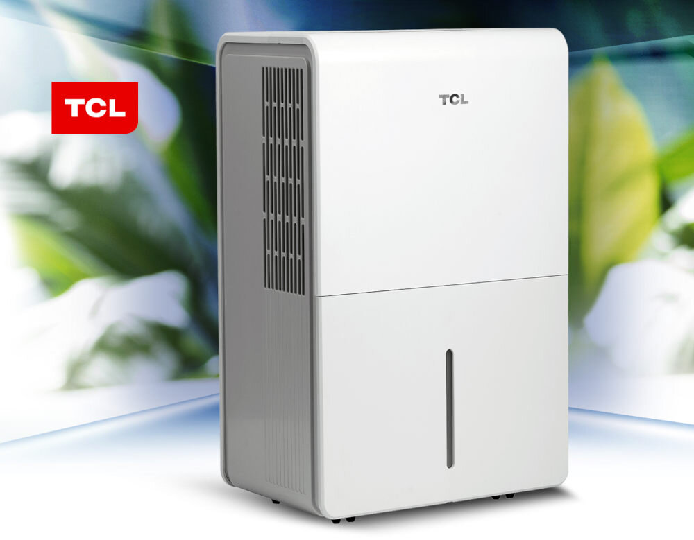Na obrazie widoczny jest biały osuszacz powietrza z logo TCL na górze. W tle znajduje się rozmyty motyw roślinny, a w lewym górnym rogu widnieje czerwone logo TCL.