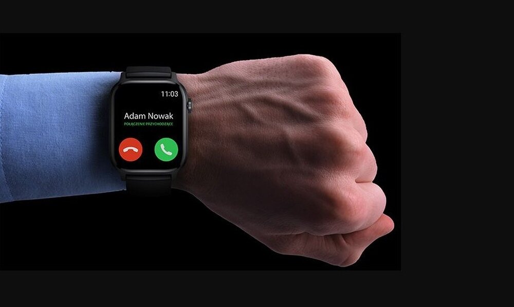 Na zdjęciu widoczny jest smartwatch na nadgarstku osoby, z wyświetlaczem pokazującym połączenie przychodzące od \'Adam Nowak\'. Na ekranie znajdują się ikony zielonej słuchawki do odebrania i czerwonej do odrzucenia połączenia.