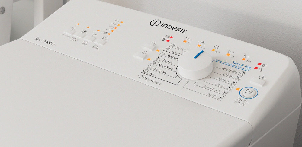 Panel sterowania pralki z logo \'indesit\' i pokrętłem wyboru programów. Widoczne są różne ikony i napisy, w tym \'Turn & Go\' oraz przycisk \'START/PAUSE\'.