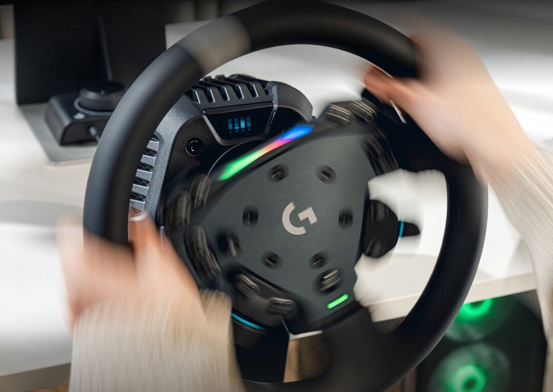 Dłonie ułożone na kierownicy LOGITECH RS50 PC w trakcie obrotu.