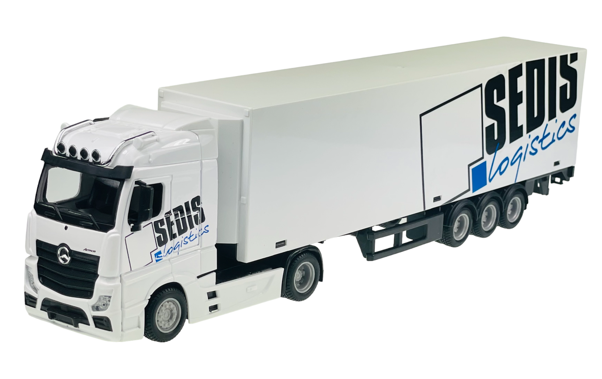 Model ciężarówki w kolorze białym z napisem \'SEDIS logistics\' na boku naczepy. Pojazd posiada trzy osie z tyłu i charakterystyczne logo na przodzie.