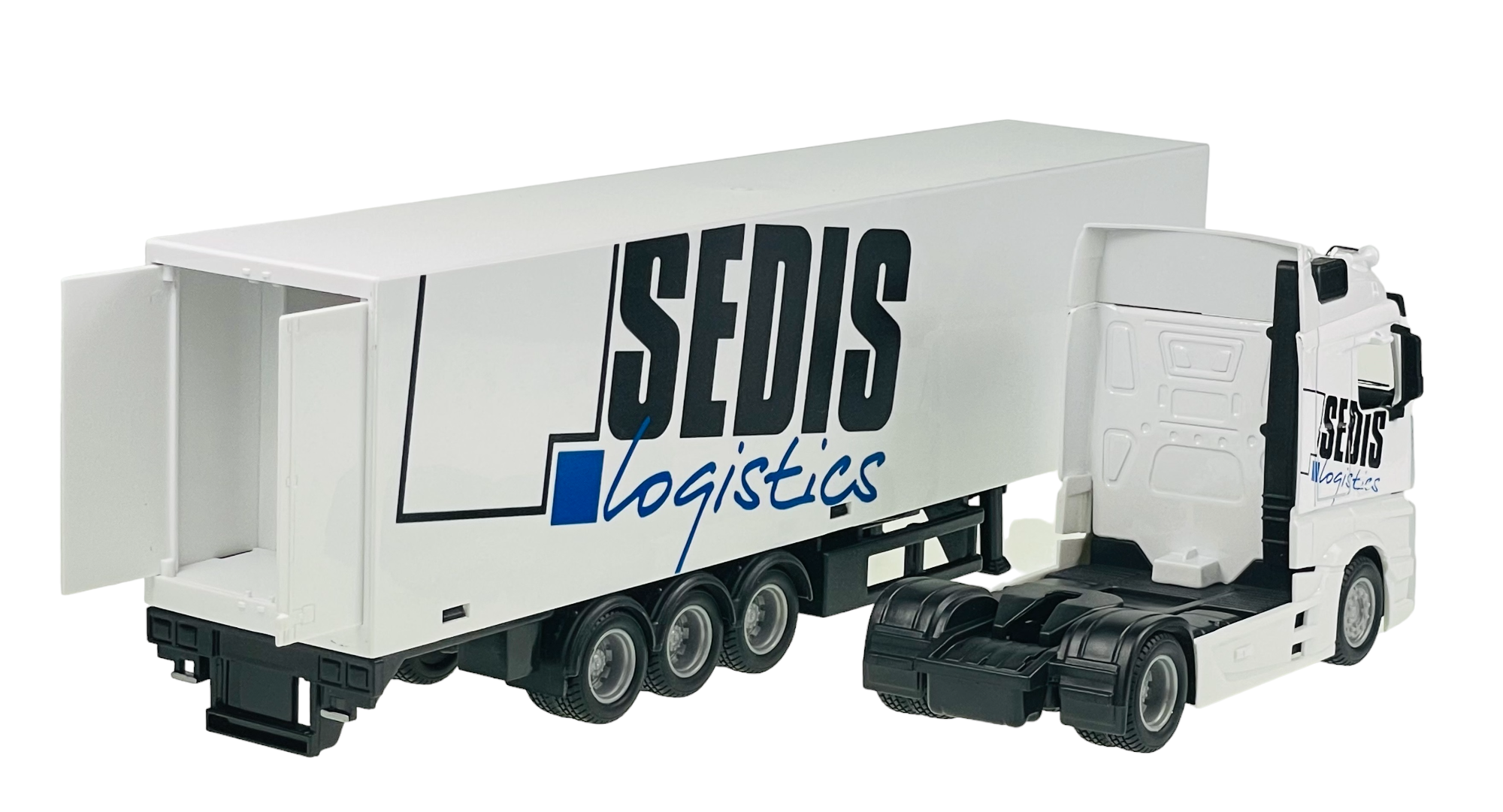Model ciężarówki z naczepą w kolorze białym z napisem \'SEDIS logistics\' na boku. Naczepa jest otwarta z tyłu, ukazując puste wnętrze.