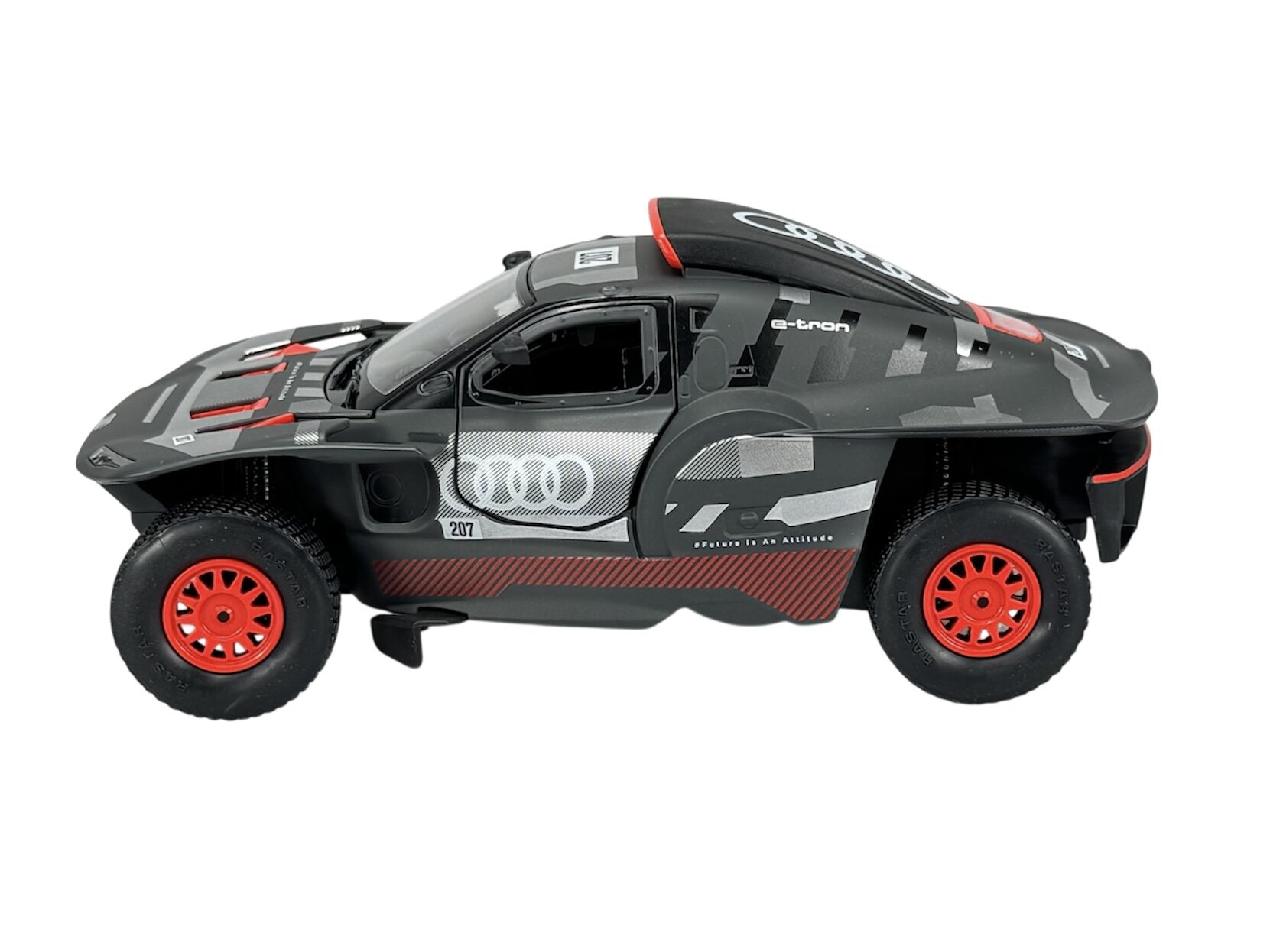 Model samochodu w skali 1:24, przedstawiający szary pojazd z czerwonymi felgami i oznaczeniami \'e-tron\' oraz logo Audi. Na dachu widoczne jest logo producenta, a na boku napis \'Driven to the extreme\'.