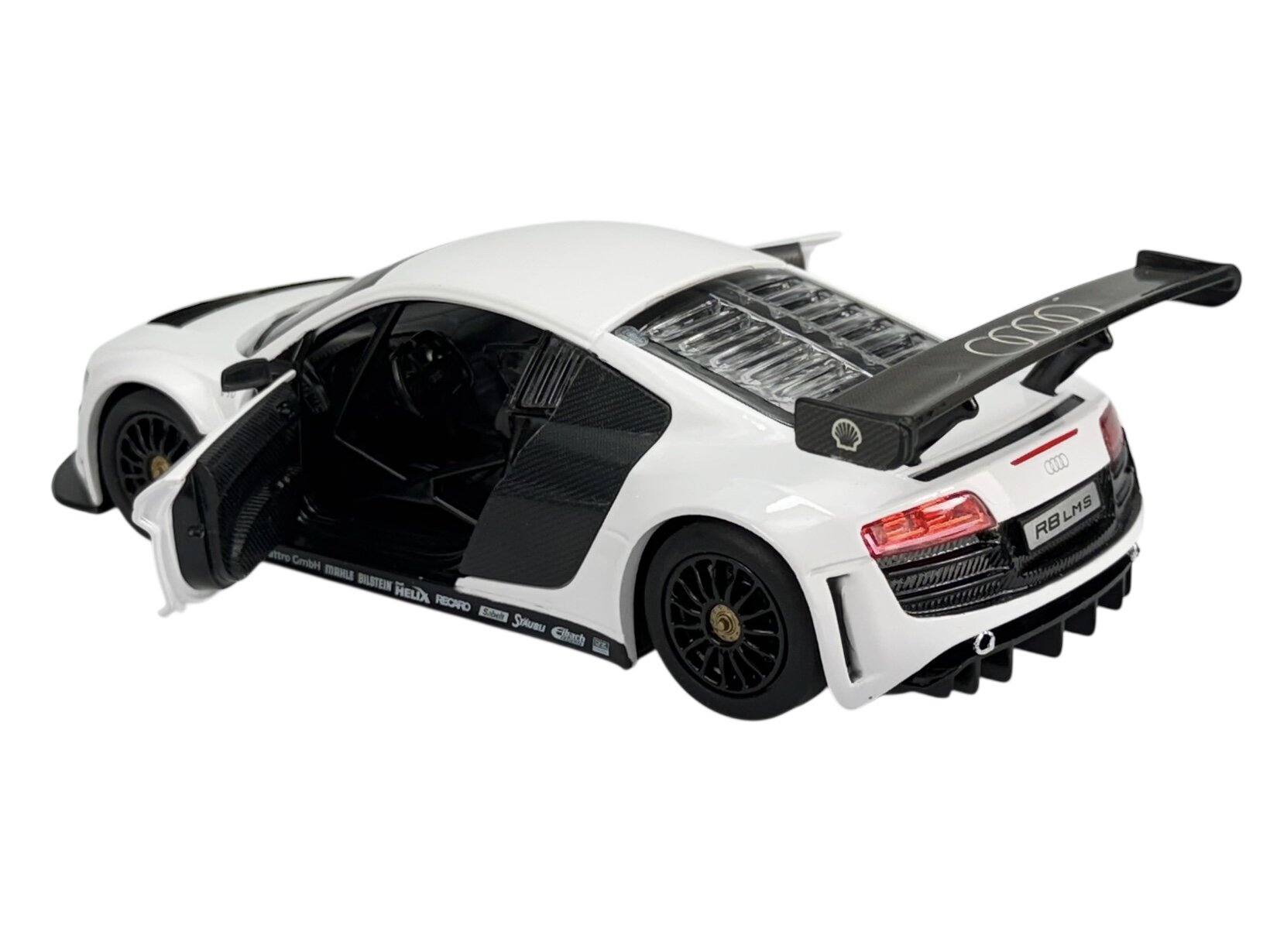 Model samochodu w kolorze białym z otwartymi drzwiami i dużym tylnym spojlerem. Na tylnej części widoczne są napisy \'R8 LMS\' oraz logo Audi.