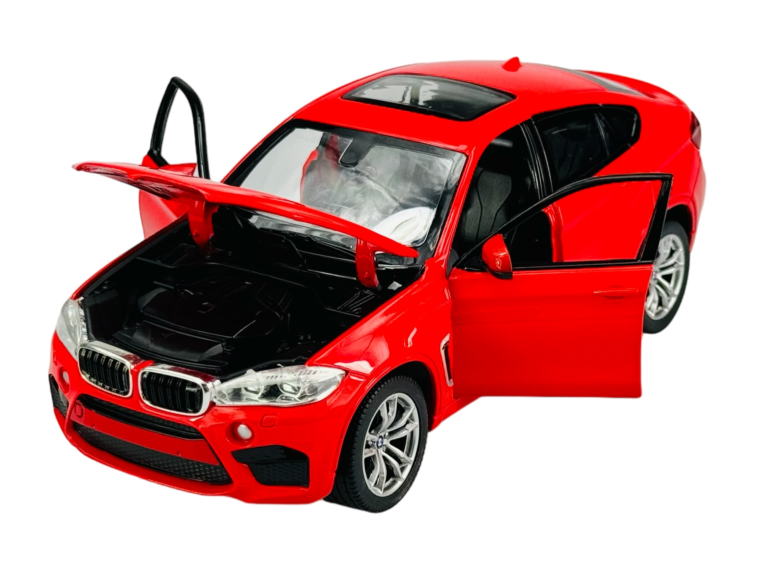 Czerwony model samochodu BMW X6M w skali 1:24 z otwartymi drzwiami i maską, ukazujący szczegóły wnętrza i silnika. Samochód stoi na przezroczystym tle.