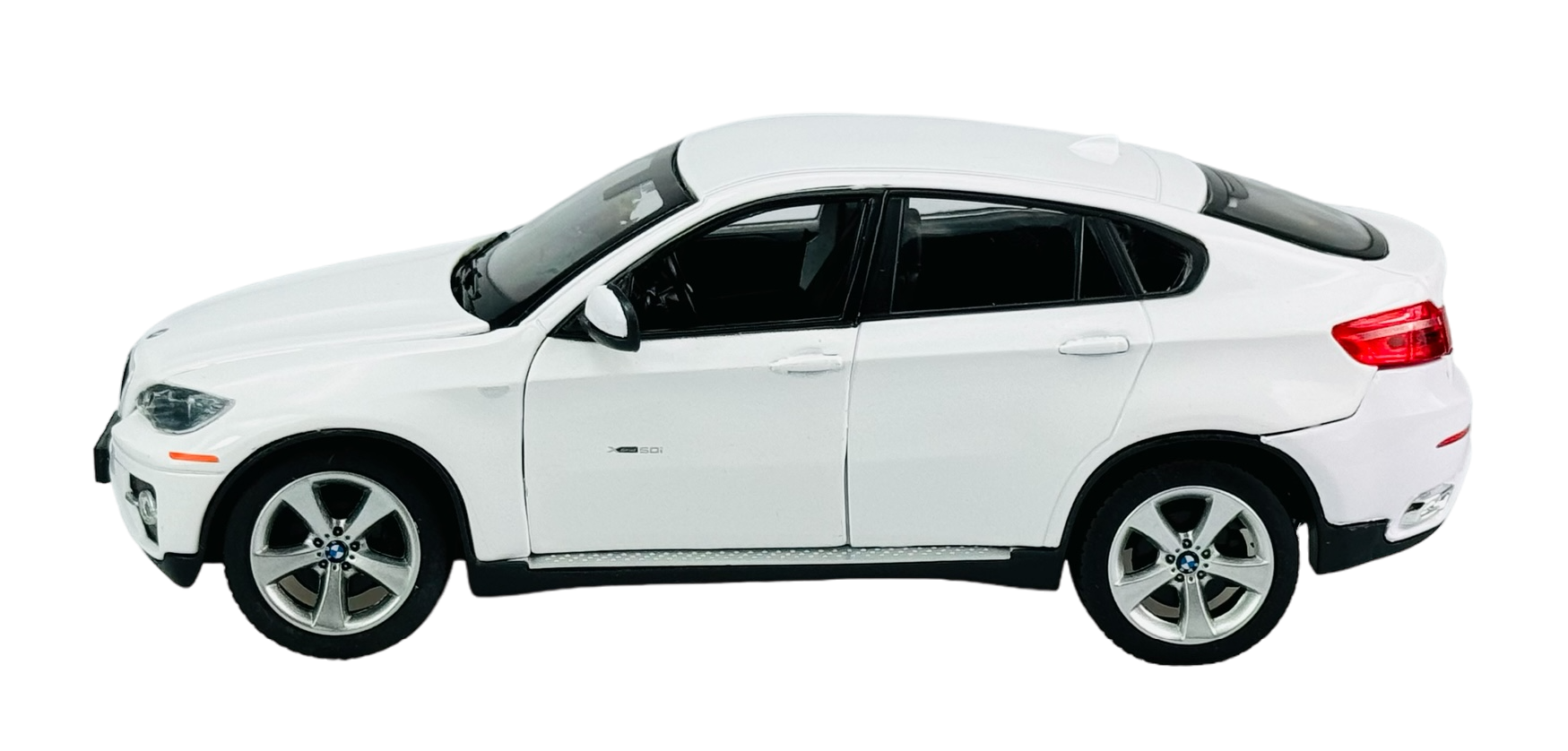 Model samochodu w kolorze białym, przypominający BMW X6, widoczny z boku na przezroczystym tle. Posiada szczegółowe elementy, takie jak felgi i lusterka boczne.