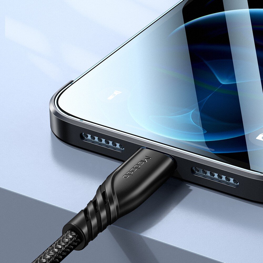 Na obrazie widać smartfon z podłączonym kablem USB-C, na którym widnieje napis \'MCDODO\'. Ekran telefonu jest włączony i wyświetla abstrakcyjne wzory.