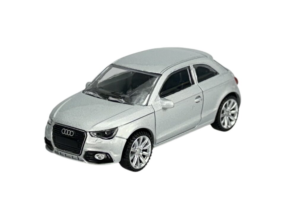 Model samochodu w skali 1:43 przedstawiający srebrny pojazd z logo Audi na przednim grillu. Samochód ma szczegółowo odwzorowane elementy, takie jak reflektory i felgi.